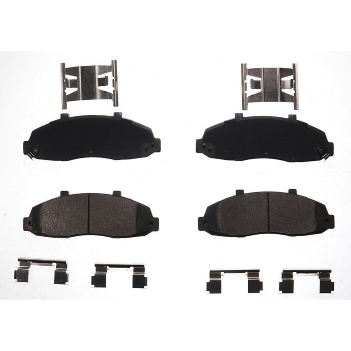 Four BFD679SM ProSeries OE Brake Pads in black, accompanied by metal clips and brackets, arranged on a white background.