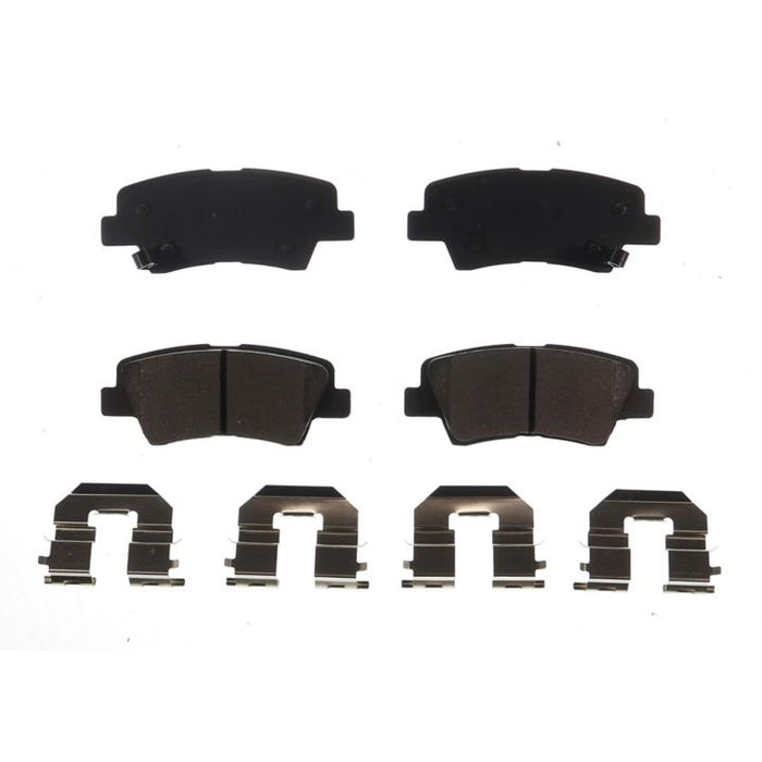 Four BFD1313CR ProSeries OE Brake Pads in black and four silver brake pad clips, symmetrically arranged on a white background.