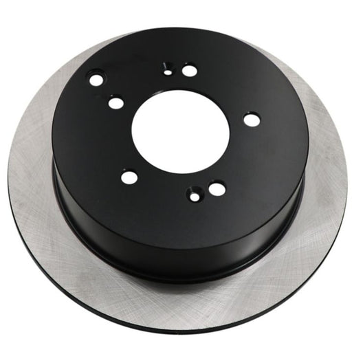 A close-up image of the C26201 ProSeries OE+ Brake Rotor, featuring a circular design with a black central hub and multiple holes.