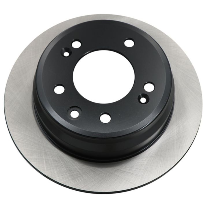 Close-up of a round, silver and black C80317 ProSeries OE+ Brake Rotor with drilled holes for mounting.