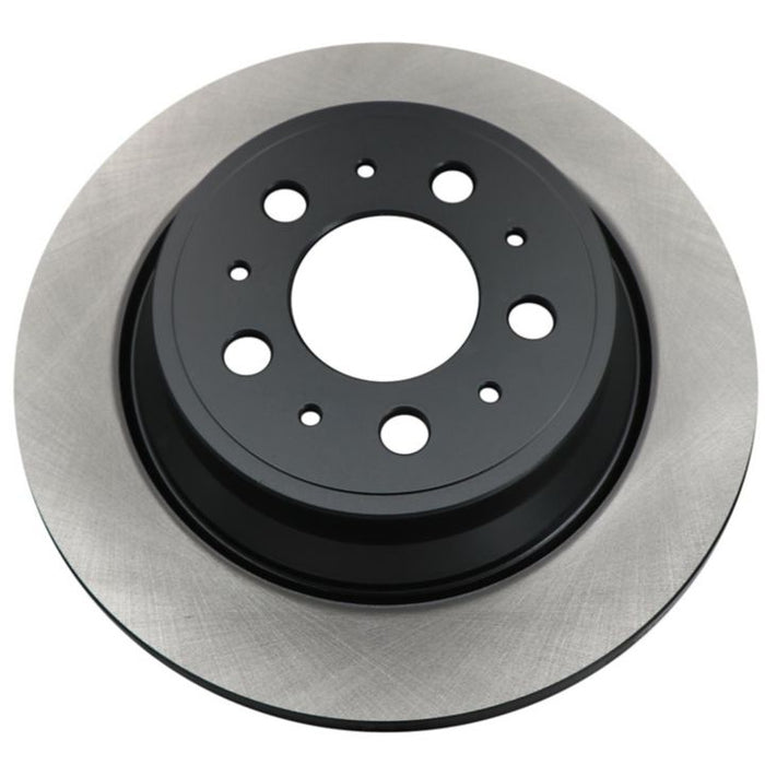 Close-up of the C26218 ProSeries OE+ Brake Rotor, featuring a metallic disc with a black center and multiple circular holes.