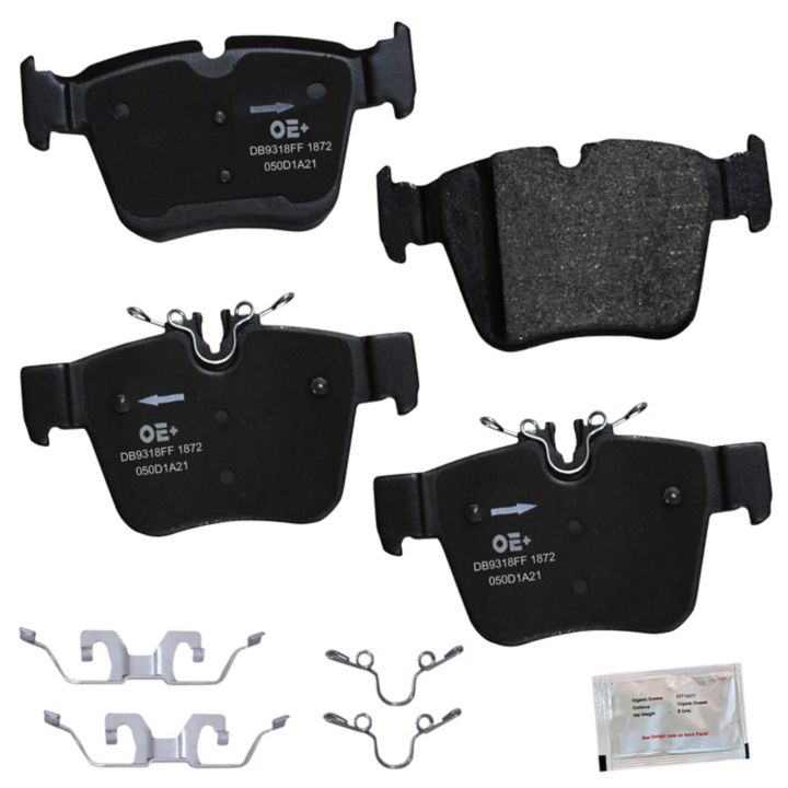 Four MMS1872 ProSeries OE+ Brake Pads, featuring metal clips and accompanied by a small packet of brake lubricant, arranged on a white background.